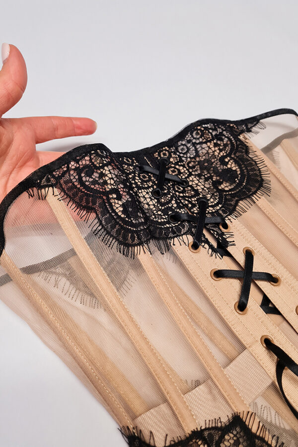 vera black flat koronka Ekspozycja beżowego gorsetu z czarną koronką na stole